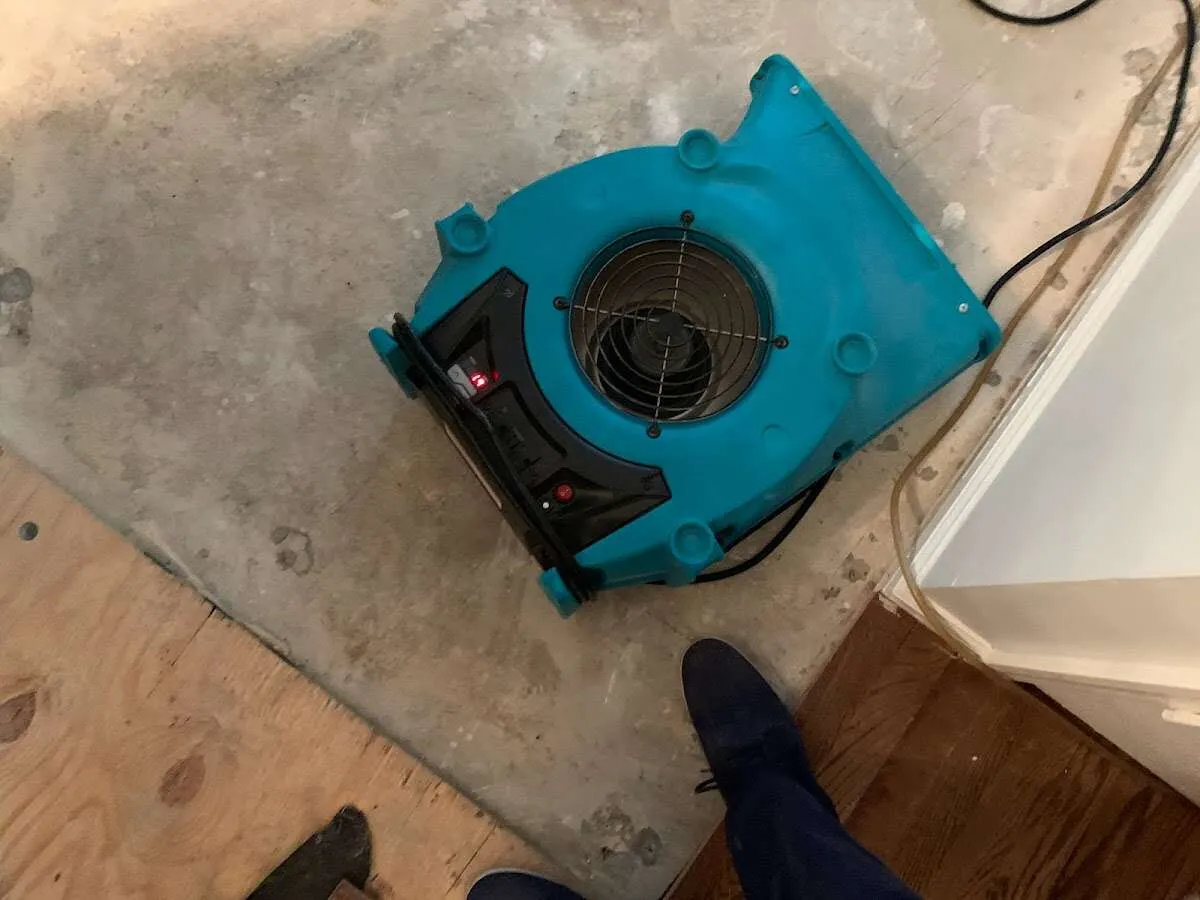 Air mover drying subfloor during Commercial Water Damage Restoration in Eagle